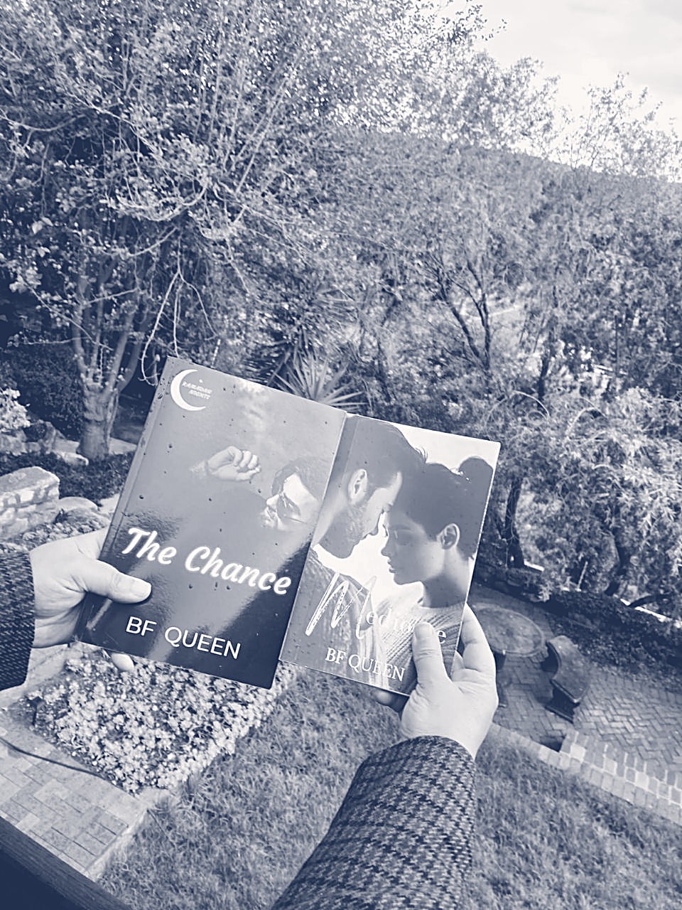 Fatima's two novels held up against a garden backdrop