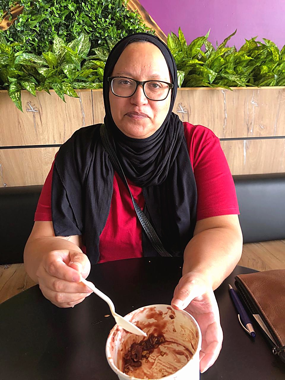 Fatima at a café table, mid-conversation over dessert
