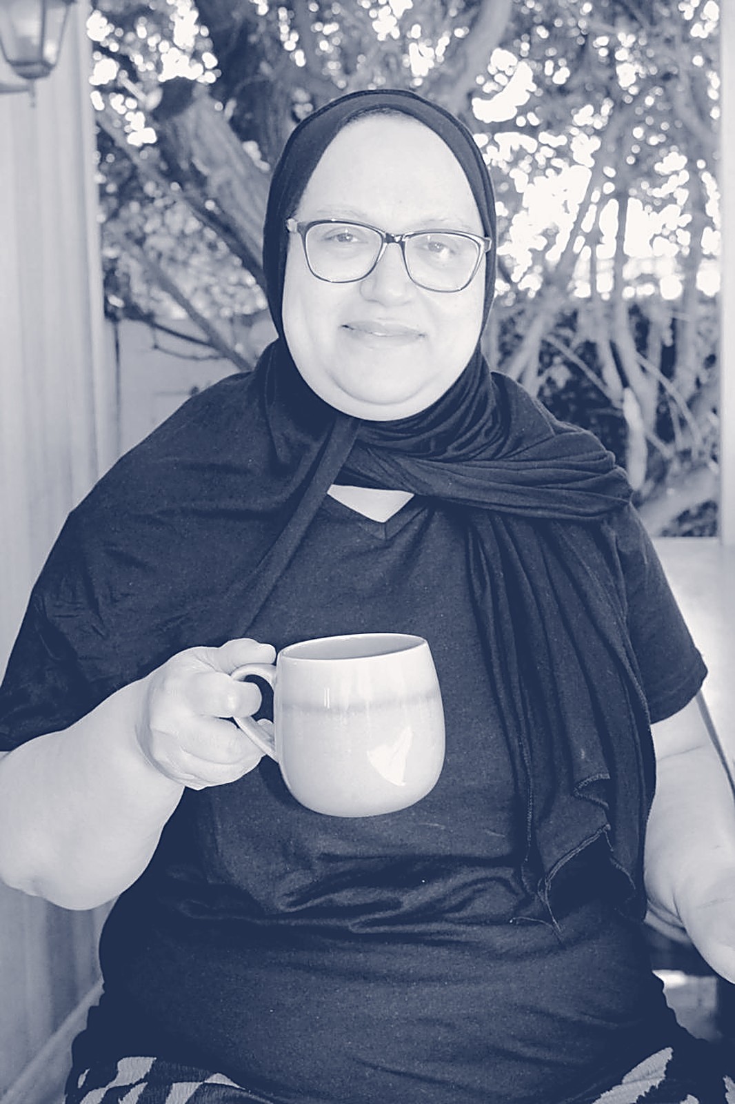 Fatima smiling with a warm mug in hand